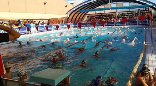 a group of people swimming in a swimming pool at Residencial el Molino Churriana in Churriana de la Vega