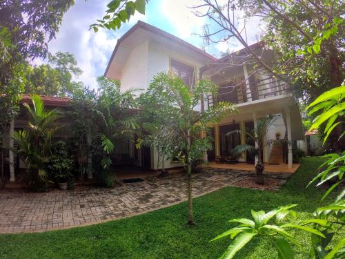 a house with a garden in front of it at Yala Southern Homestay in Tissamaharama