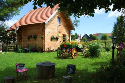 a wooden house with a wagon in the yard at Apartments Vila Selena - Golija in Rudno