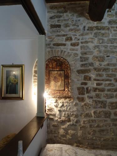 una stanza con un muro in pietra e una luce sopra di Non ditelo al Duca - Lo Spagna a Spoleto