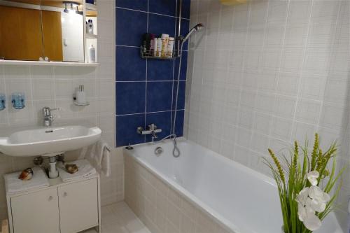 ein Badezimmer mit einem Waschbecken, einer Badewanne und einem Waschbecken in der Unterkunft Freihof Embrach in Embrach