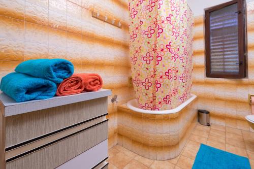 a bathroom with towels on shelves and a shower at Apartment Villa Olga in Poreč