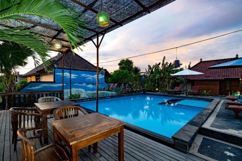 a patio with a table and chairs next to a swimming pool at Sedok Jineng Villa Lembongan in Nusa Lembongan