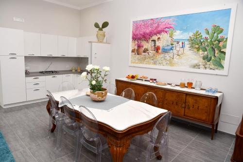 a kitchen with a table and a painting on the wall at DolceLina Home in Lampedusa