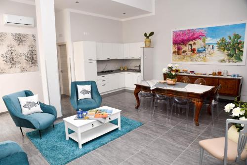a living room with a table and chairs and a kitchen at DolceLina Home in Lampedusa