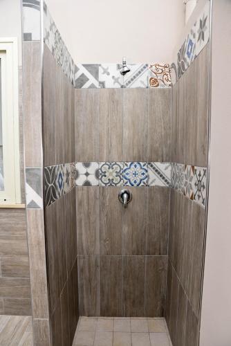 a bathroom with a shower with tiles on the wall at DolceLina Home in Lampedusa