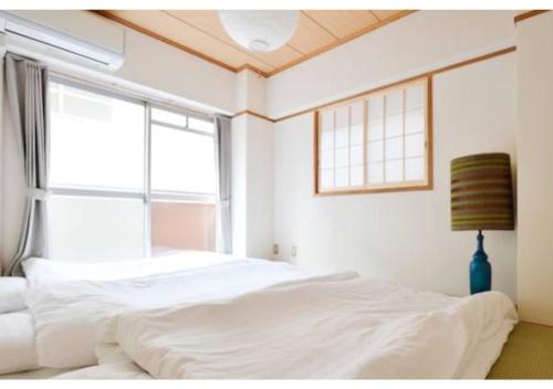 sypialnia z 2 łóżkami i dużym oknem w obiekcie Daihan Building / Vacation STAY 3304 w Osace