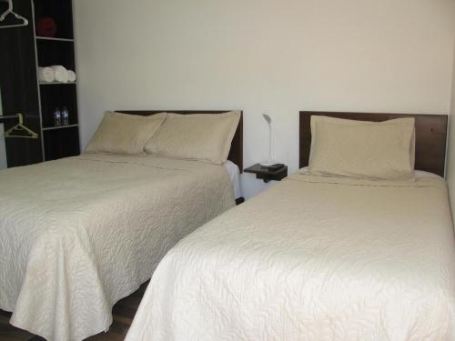 two beds sitting next to each other in a bedroom at Los Vagones de William in Tibasosa