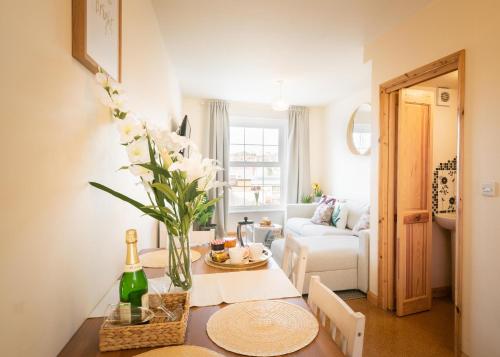 una sala de estar con una mesa con un jarrón de flores en St Sidwells Townhouses' en Exeter