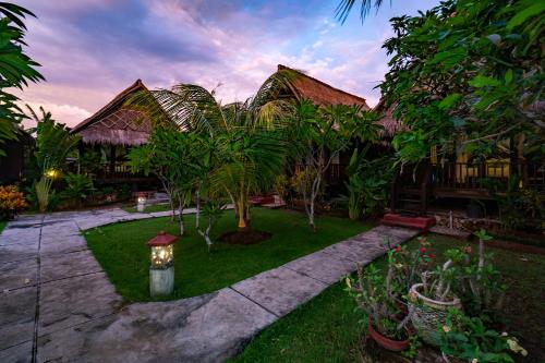 a house with a garden with a light in the yard at Sedok Jineng Villa Lembongan in Nusa Lembongan