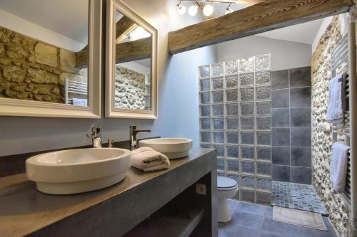 a bathroom with a sink and a toilet and a mirror at Chambres d'hôtes Domaine de Ginouilhac in Le Taillan-Médoc