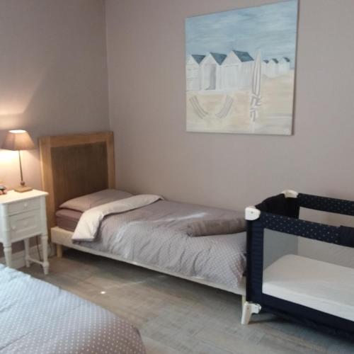 une chambre avec deux lits et un tableau au mur dans l'établissement charmante maison de pêcheur typique, à Trouville-sur-Mer