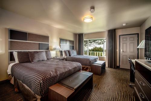 a hotel room with a bedroom with a bed and a couch at Crescent Bay Inn in Laguna Beach