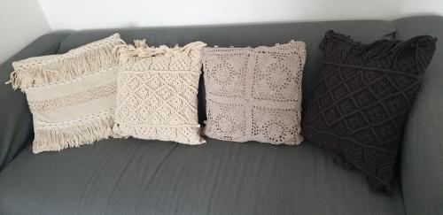 three white pillows are sitting on a couch at Gîtes Les 3 Tours 2 in Carcassonne