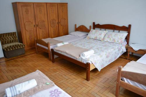 um quarto com uma cama e um banco e uma cama e uma cadeira em Pousada do Barão em São Lourenço