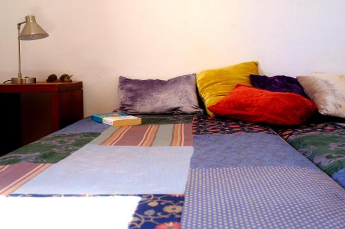 una cama con almohadas coloridas encima en La Posidonia en Rodalquilar