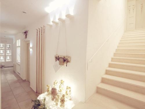 a hallway with white walls and stairs in a house at Le Nicchie Guest House in Lucera
