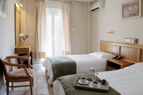 una habitación de hotel con 2 camas y una silla en Pella, en Tesalónica