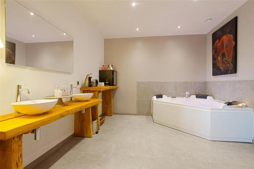 a bathroom with two sinks and a bath tub at B&B/Boertel de Meander in Oirschot
