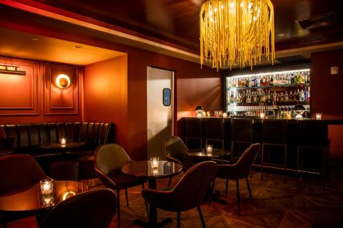 un restaurant avec des tables et un bar avec un lustre dans l'établissement Hotel 32 32, à New York