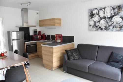 un salon avec un canapé et une cuisine dans l'établissement Gîte Le Welcome, à Wimereux