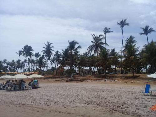 a group of people sitting at a table on the beach at Linda casa na Praia do Flamengo in Salvador