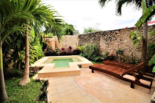 un jardín con banco y piscina en Casa Tia Micha en Valladolid