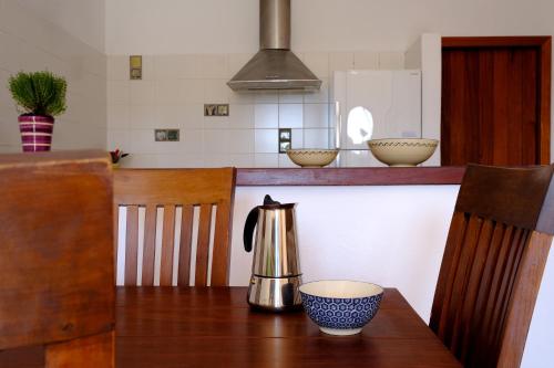 una cocina con mesa y hervidor de agua. en La Posidonia, en Rodalquilar