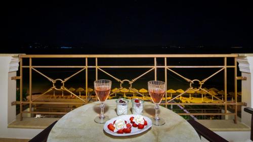 a table with two glasses of champagne and a plate of food at Ilia Mare in Ilia