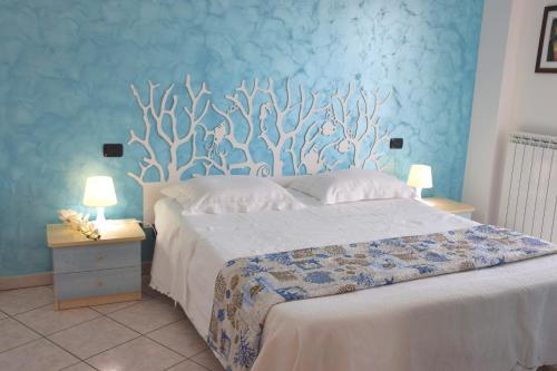 een slaapkamer met een groot bed met een blauwe muur bij Residence Acquamarina in San Benedetto del Tronto