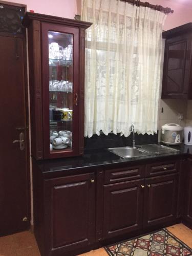 a kitchen with a sink and a glass cabinet at Ivory Home Stay & Self-Catering Guest House in Ja-Ela