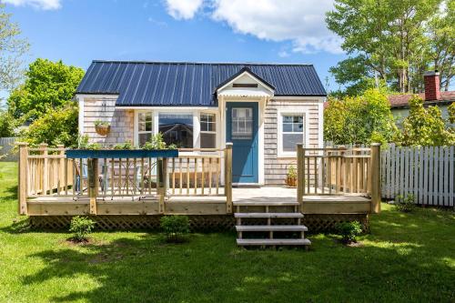 a tiny house with a deck and a blue door at Seaside Beach Resort in Saint Andrews
