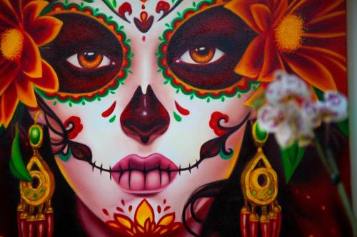 a woman with her face painted like a clown at Mestizo Gallery in Tulum