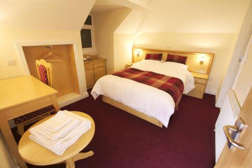 a hotel room with a large bed and a table at Gateway Hotel in Newport