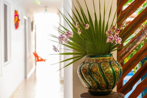 a vase with flowers in it sitting on a table at Mestizo Gallery in Tulum