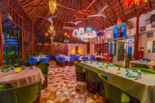 a restaurant with tables and chairs in a room at Mestizo Gallery in Tulum