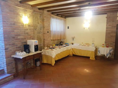 een grote kamer met 2 tafels en een bakstenen muur bij Il Borgo sul Lago in Monte del Lago