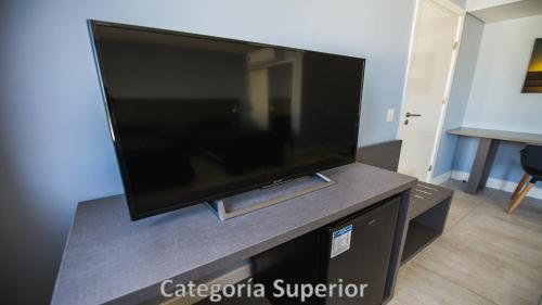 a flat screen tv sitting on top of a entertainment center at Hotel AATRAC in Mar del Plata