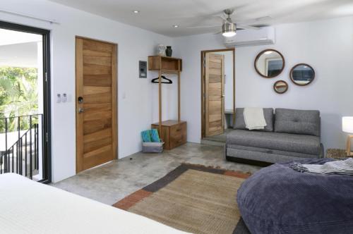 a bedroom with a bed and a couch and a door at Villas Robalo / Dorado Penthouses in Sayulita