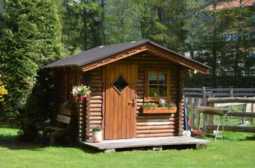 a small wooden cabin with a window and a door at Scheibenhof in Bad Gastein