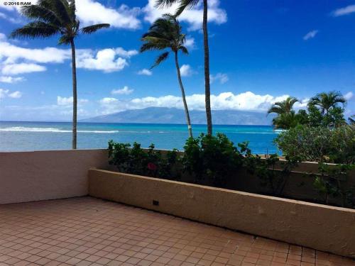 a view of the ocean from a balcony with palm trees at Deluxe Oceanview Maui Studio..New & Updated in Kahana