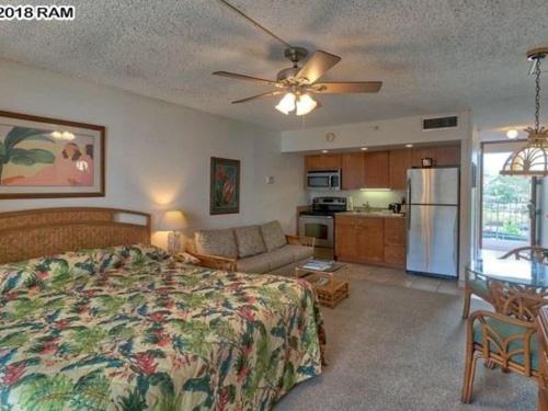 a bedroom with a bed and a couch and a kitchen at Deluxe Oceanview Maui Studio..New & Updated in Kahana
