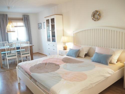 Ferienwohnung preiswert und strandnah في فارنمونده: غرفة نوم بسرير كبير وغرفة طعام