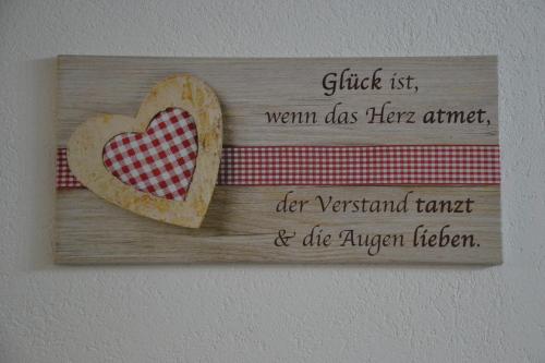 a wooden sign with a heart on a wall at Ferienwohnung Emil in Immenstadt im Allgäu
