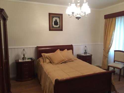 a bedroom with a bed with two tables and a chandelier at Vivenda Garcia Bed and Breakfast in Relva