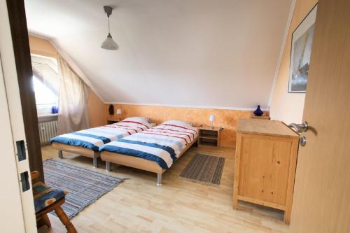 Zimmer mit 4 Betten, einem Tisch und einer Tür in der Unterkunft Haus Buchholz in Liesenich