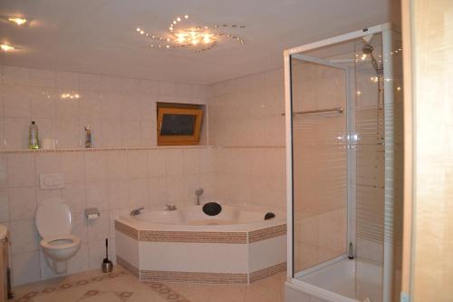 een badkamer met een douche, een bad en een toilet bij Ferienwohnung Emil in Immenstadt im Allgäu