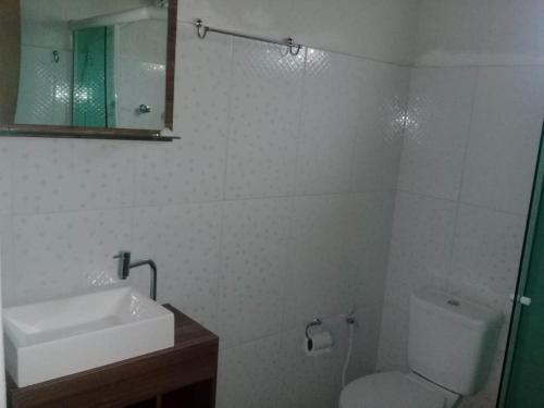 ein Badezimmer mit einem Waschbecken, einem WC und einem Spiegel in der Unterkunft Chalé duplex reformado - Fazenda Cantinho in Teresópolis