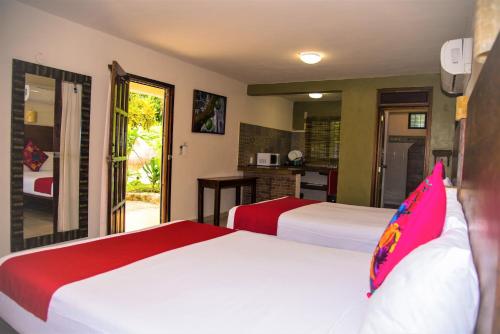 a hotel room with two beds and a kitchen at El Roble Nature Hotel & Lagoon in Bacalar