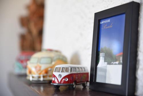 a small toy bus is next to a picture frame at Surf House Peniche in Baleal